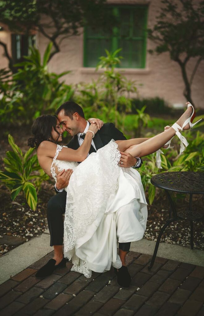 A bride and groom hugging on a brick patio.